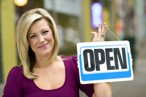 Woman holding open sign